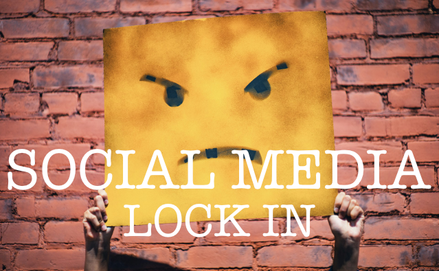 Yellow sign with angry eyes reads "SOCIAL MEDIA LOCK IN" against brick wall background.